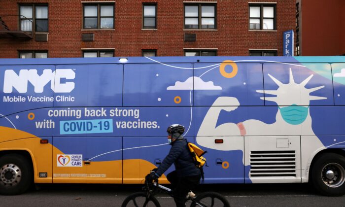 A person rides a bicycle past a mobile COVID-19 vaccine clinic in Manhattan, New York, on Dec. 7, 2021. (Andrew Kelly/Reuters)