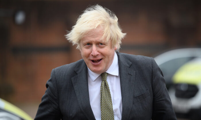 Britain's Prime Minster Boris Johnson speaks with police officers as he makes a constituency visit to Uxbridge police station in London on Dec. 17, 2021. (Leon Neal/Getty Images)
