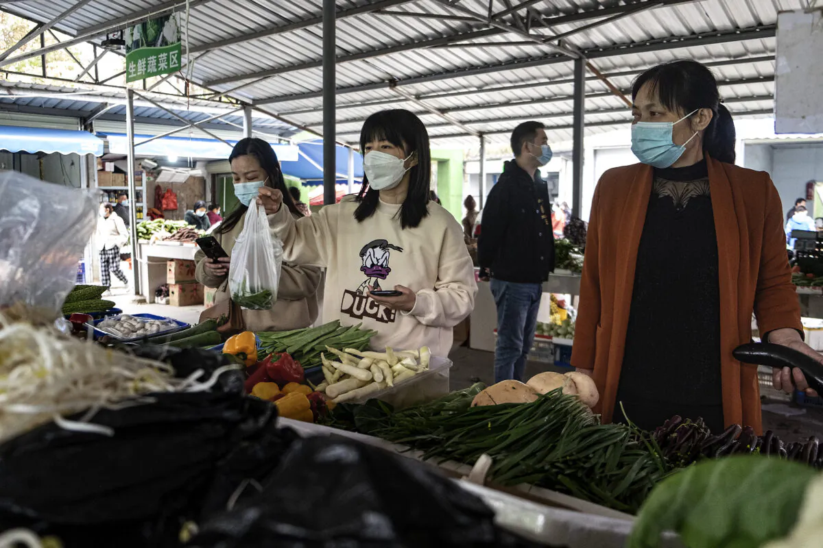 Residents 
wear protective masks while buying vegetables at an open market on November 20, 2021 in Wuhan, China. (Getty Images)