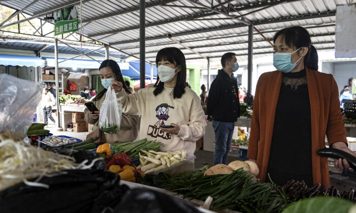 Residents 
wear protective masks while buying vegetables at an open market on November 20, 2021 in Wuhan, China. (Getty Images)