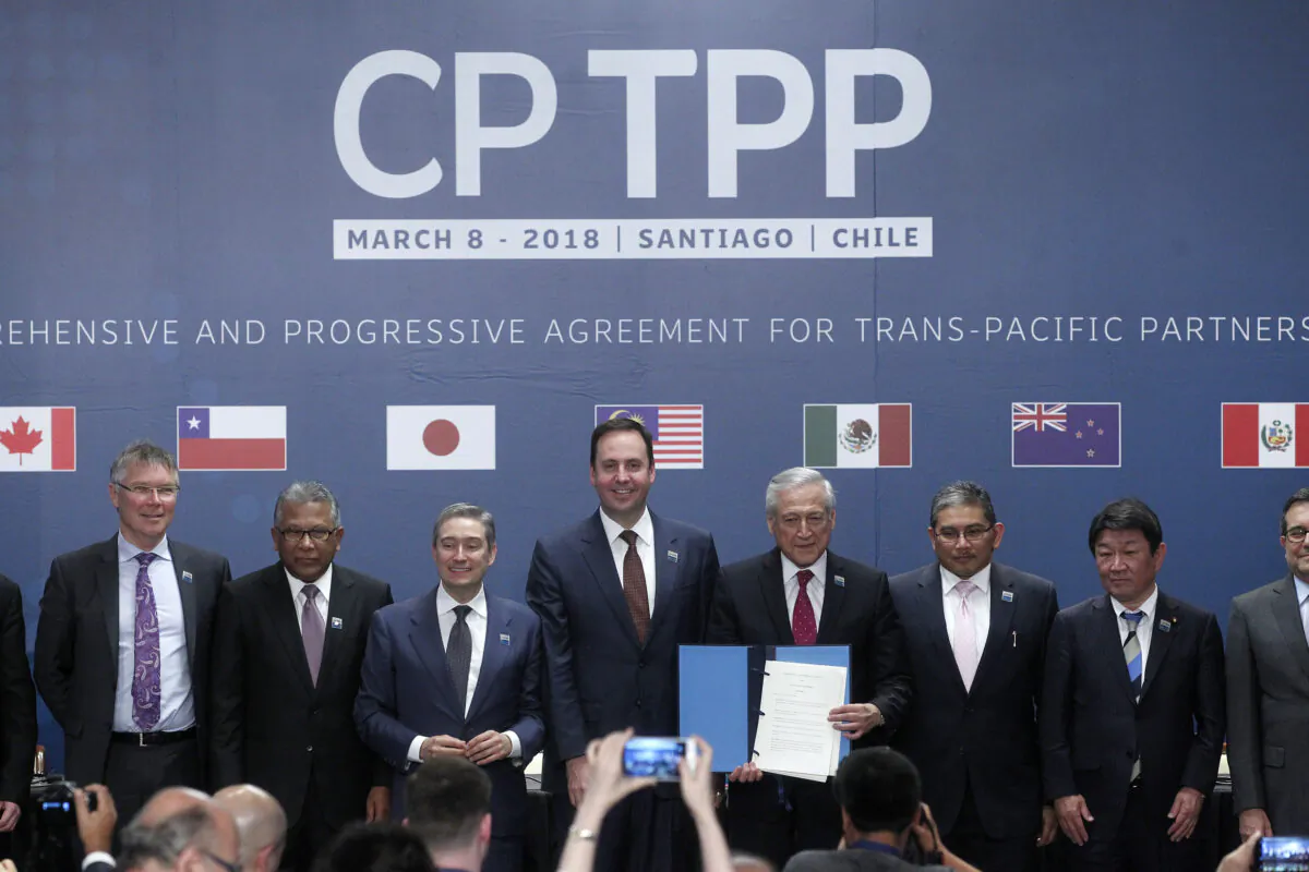 (L-R) Trade or foreign ministers of Singapore, New Zealand, Malaysia, Canada, Australia, Chile, Brunei, Japan, Mexico, Peru, and Vietnam pose for an official picture after signing the rebranded 11-nation Pacific trade pact Comprehensive and Progressive Agreement for Trans-Pacific Partnership (CPTPP) in Santiago, on March 8, 2018. (Claudio Reyes/AFP via Getty Images)