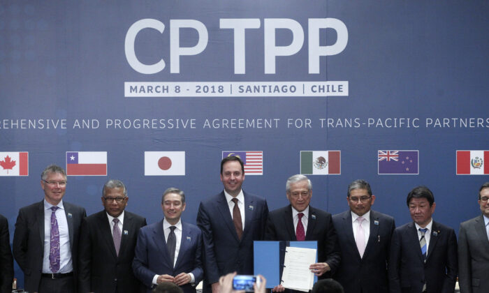 (L-R) Trade or foreign ministers of Singapore, New Zealand, Malaysia, Canada, Australia, Chile, Brunei, Japan, Mexico, Peru, and Vietnam pose for an official picture after signing the rebranded 11-nation Pacific trade pact Comprehensive and Progressive Agreement for Trans-Pacific Partnership (CPTPP) in Santiago, on March 8, 2018. (Claudio Reyes/AFP via Getty Images)