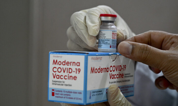 A health worker checks a box of the Moderna COVID-19 vaccine donated by the United States, during a booster vaccination drive at the Zainoel Abidin hospital in Banda Aceh, Indonesia, on Aug. 9, 2021. (Chaideer Mahyuddin/AFP via Getty Images)