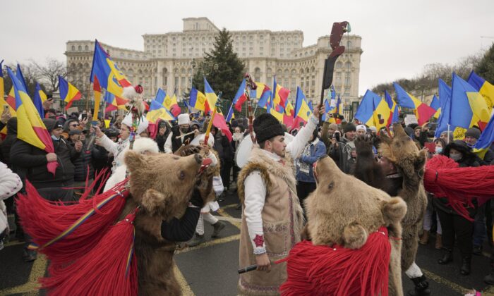 Romanians protesting the introduction of a COVID-19 "green pass" in the workplace gather outside the Palace of Parliament in Bucharest, Romania, on Dec. 21, 2021. (Vadim Ghirda/AP Photo)