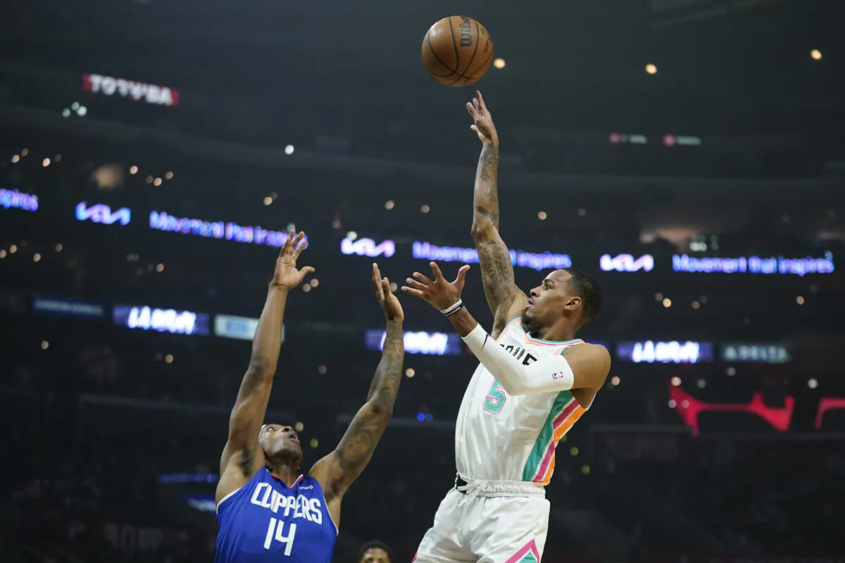 San Antonio Spurs guard Dejounte Murray (5) shoots against Los Angeles Clippers guard Terance Mann (14) during the first half of an NBA basketball game in Los Angeles on Dec. 20, 2021. (AP Photo/Ashley Landis)