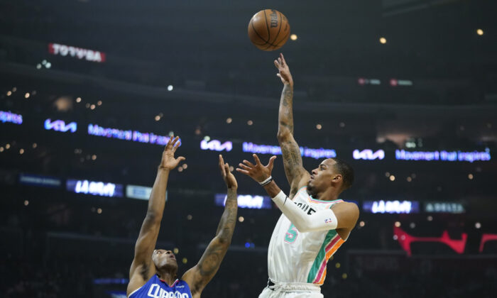 San Antonio Spurs guard Dejounte Murray (5) shoots against Los Angeles Clippers guard Terance Mann (14) during the first half of an NBA basketball game in Los Angeles on Dec. 20, 2021. (AP Photo/Ashley Landis)