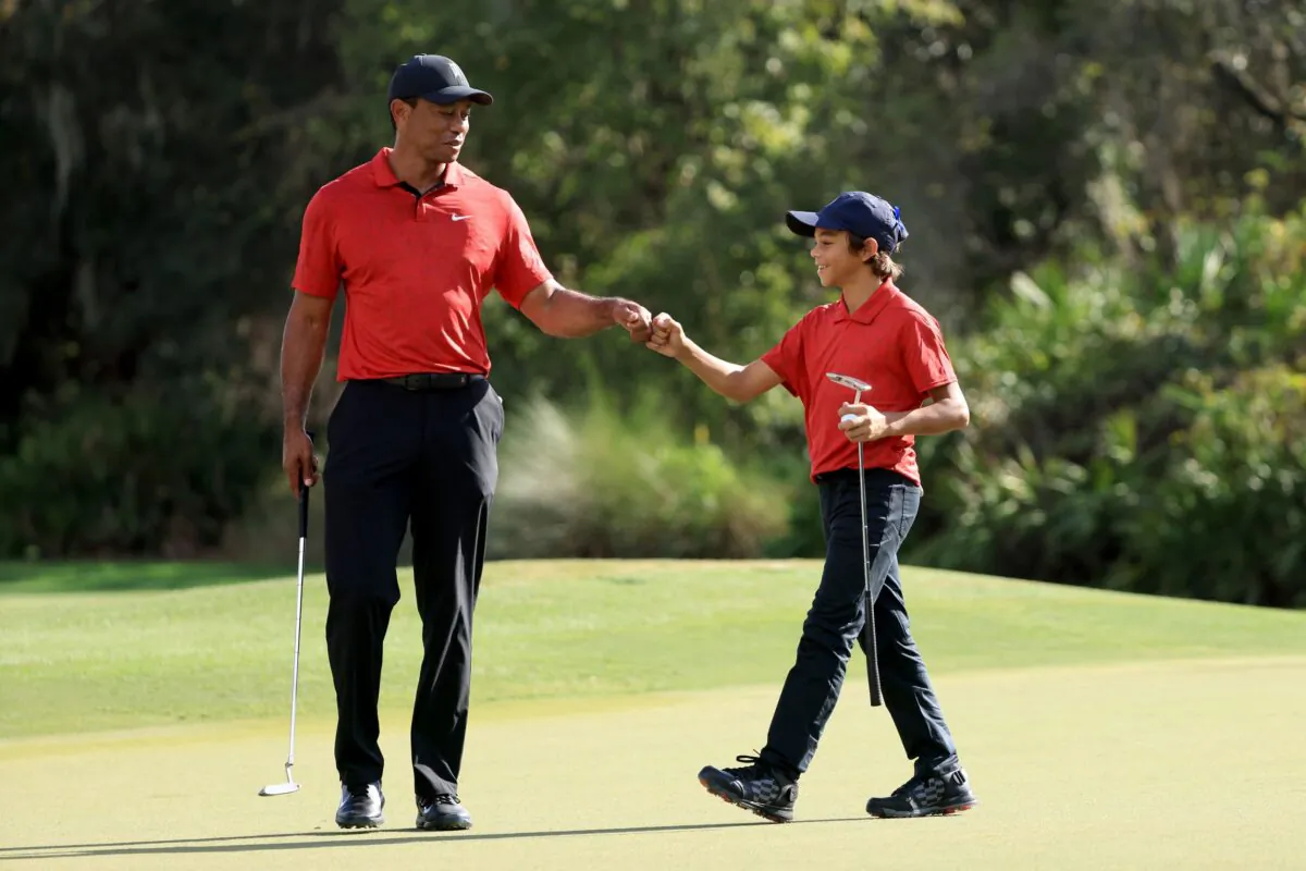 Tiger Woods and Charlie Woods celebrate a birdie on the 12th hole during the final round of the PNC Championship at the Ritz Carlton Golf Club Grande Lakes in Orlando, Fla., on Dec. 19, 2021. (Sam Greenwood/Getty Images)