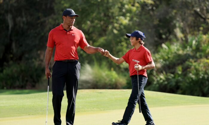 Tiger Woods and Charlie Woods celebrate a birdie on the 12th hole during the final round of the PNC Championship at the Ritz Carlton Golf Club Grande Lakes in Orlando, Fla., on Dec. 19, 2021. (Sam Greenwood/Getty Images)