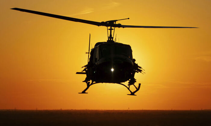 Gunners watch from the doors of a Helibacon helicopter at sunset. (HeliBacon)