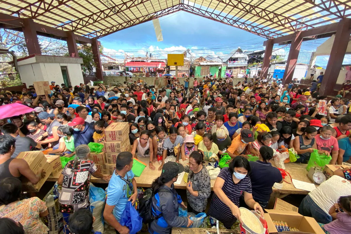People affected by the typhoon Rai gather during a distribution of relief goods, in Surigao City, Surigao del Norte, Philippines, on Dec. 20, 2021. (Erwin Mascarinas/Greenpeace/Handout via Reuters)
