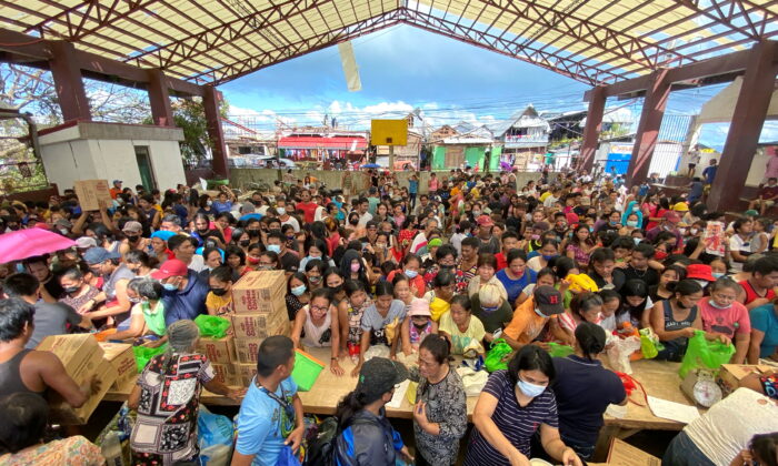 People affected by the typhoon Rai gather during a distribution of relief goods, in Surigao City, Surigao del Norte, Philippines, on Dec. 20, 2021. (Erwin Mascarinas/Greenpeace/Handout via Reuters)