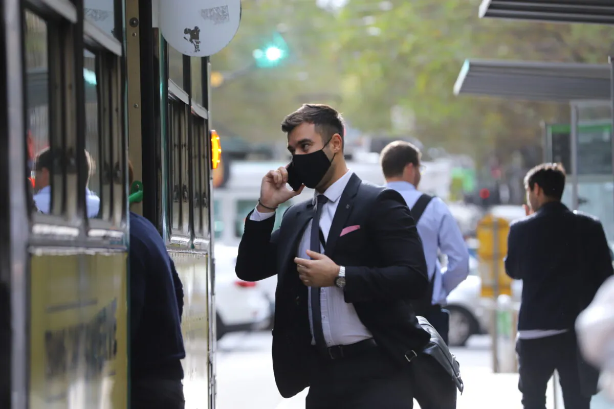 An office worker is seen wearing a face mask while getting on a tram at Collins Street in Melbourne, Australia, on April 15, 2021. (AAP Image/Diego Fedele)