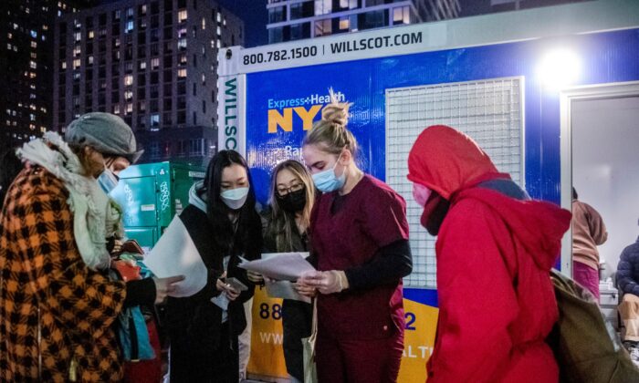 People check their rapid COVID-19 test results outside of a testing site on the Lower East Side of Manhattan in New York on Dec. 21, 2021. (Brittainy Newman/AP Photo)