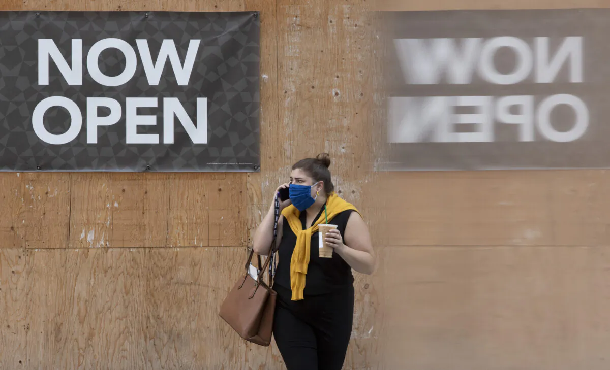 A woman speaks on the phone on a sidewalk in downtown Ottawa on July 24, 2020. (Adrian Wyld/The Canadian Press)