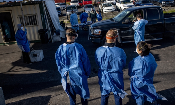 Health care workers administer free COVID-19 tests to people in their cars in the parking lot of the Columbus West Family Health and Wellness Center in Columbus, Ohio on Nov. 19, 2020. (Stephen Zenner/AFP via Getty Images)