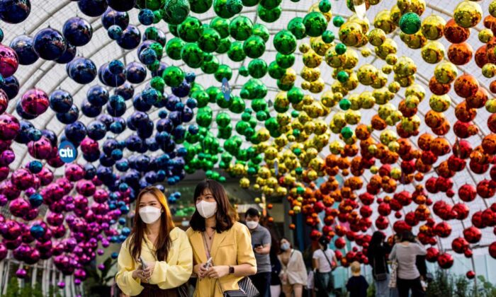 Women wearing face masks walk below decorations outside a shopping mall in Bangkok on Dec. 6, 2021, as Thailand recorded its first case of the coronavirus Omicron variant. (Jack Taylor/AFP)