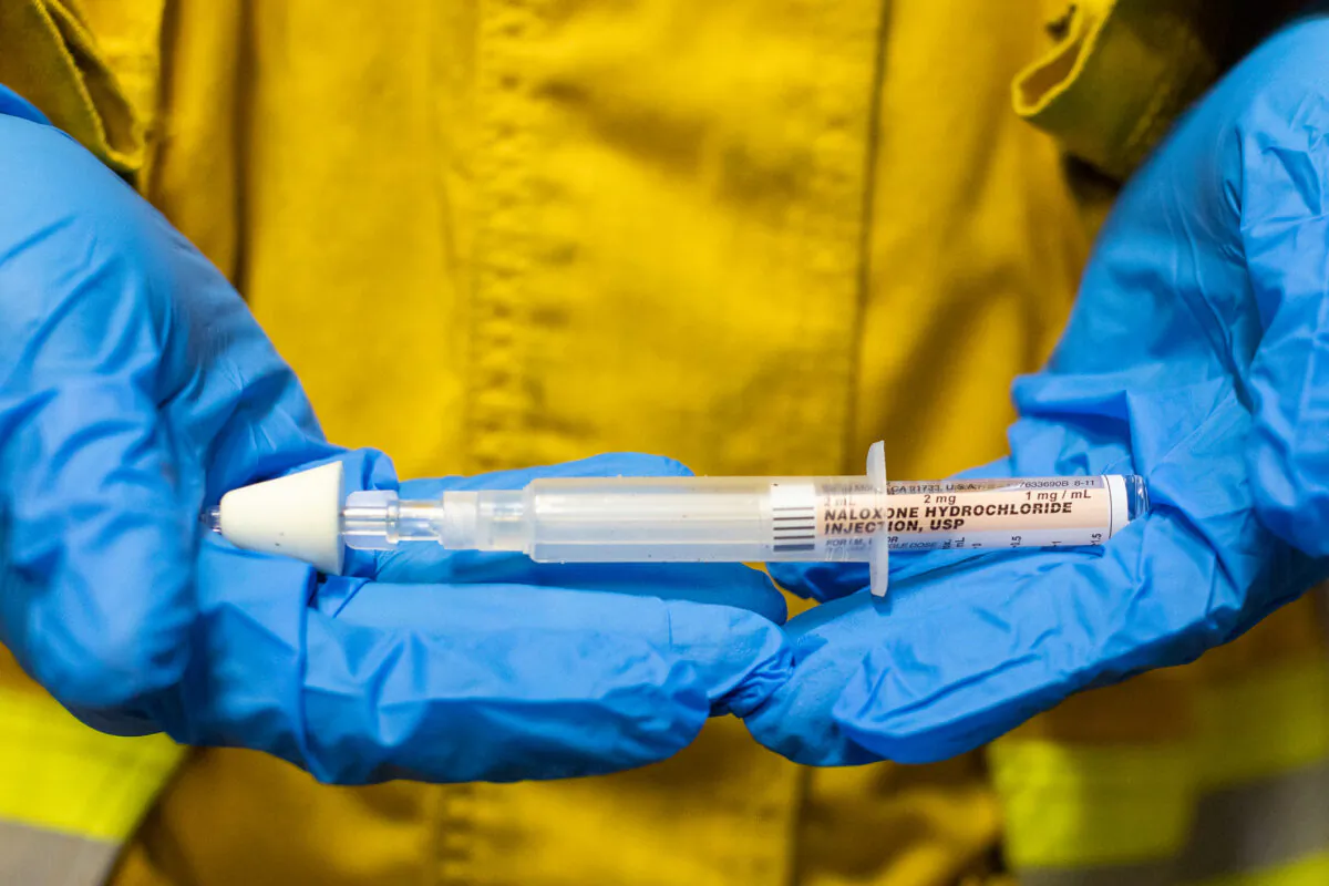 A firefighter displays naloxone, a medication used to reverse opioid overdoses, on Feb. 26, 2021. (John Fredricks/The Epoch Times)