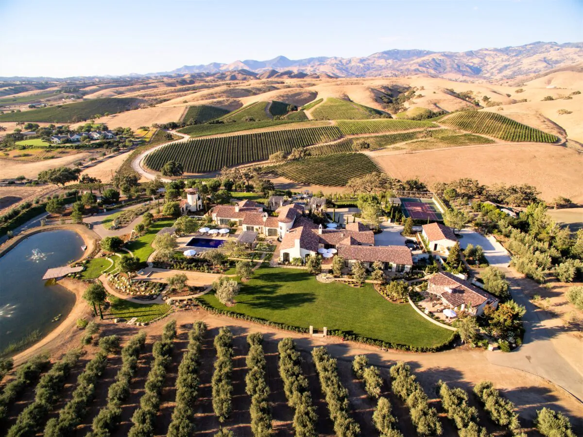 An aerial view of the estate shows the lush surroundings, horse farms, vineyards, and the San Rafael Mountains beyond. (Matthew Walla/Jade Mills)