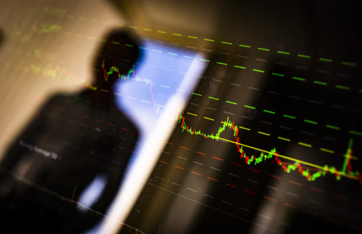A man looks at a stock market chart in Irvine, Calif., on April 9, 2021. (John Fredricks/The Epoch Times)