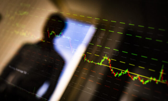 A man looks at a stock market chart in Irvine, Calif., on April 9, 2021. (John Fredricks/The Epoch Times)