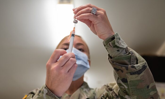 A military member prepares a COVID-19 vaccine in Fort Knox, Ky., on Sept. 9, 2021. (Jon Cherry/Getty Images)