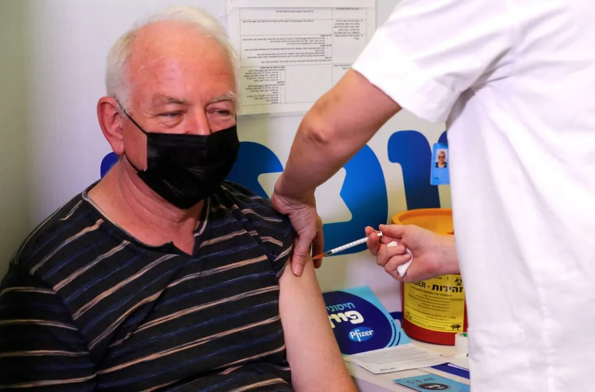 An Israeli health worker administers a dose of the Pfizer-BioNtech COVID-19 vaccine to a man, at the Maccabi Health Service in the Israeli town of Rishon Lezion, Israel, in August 2021. (Ahmad Gharabli/AFP via Getty Images)