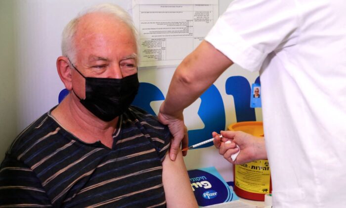 An Israeli health worker administers a dose of the Pfizer-BioNtech COVID-19 vaccine to a man, at the Maccabi Health Service in the Israeli town of Rishon Lezion, Israel, in August 2021. (Ahmad Gharabli/AFP via Getty Images)