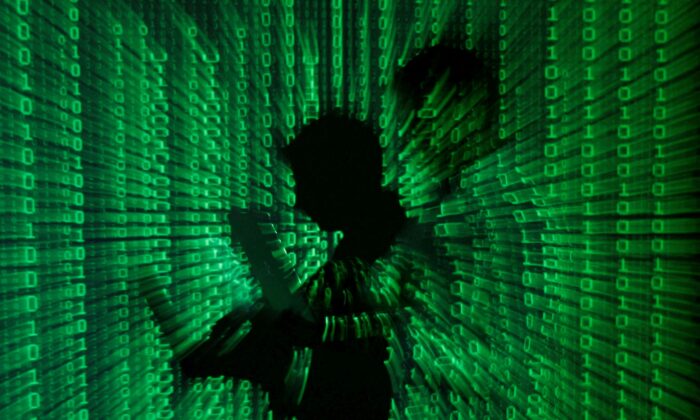 An illustration picture shows a projection of binary code on a man holding a laptop computer, in an office in Warsaw on June 24, 2013. (Kacper Pempel/Reuters)