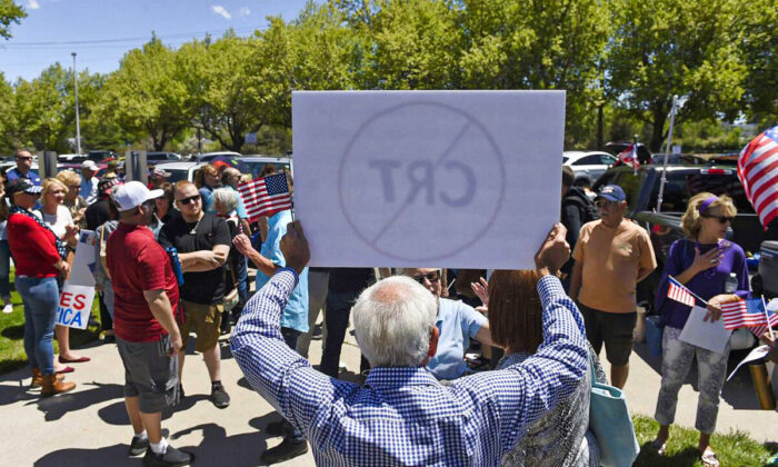 A man holds up a sign against critical race theory during a protest outside a Washoe County School District board meeting in Reno, Nev., on May 25, 2021. (Andy Barron/Reno Gazette-Journal via AP)