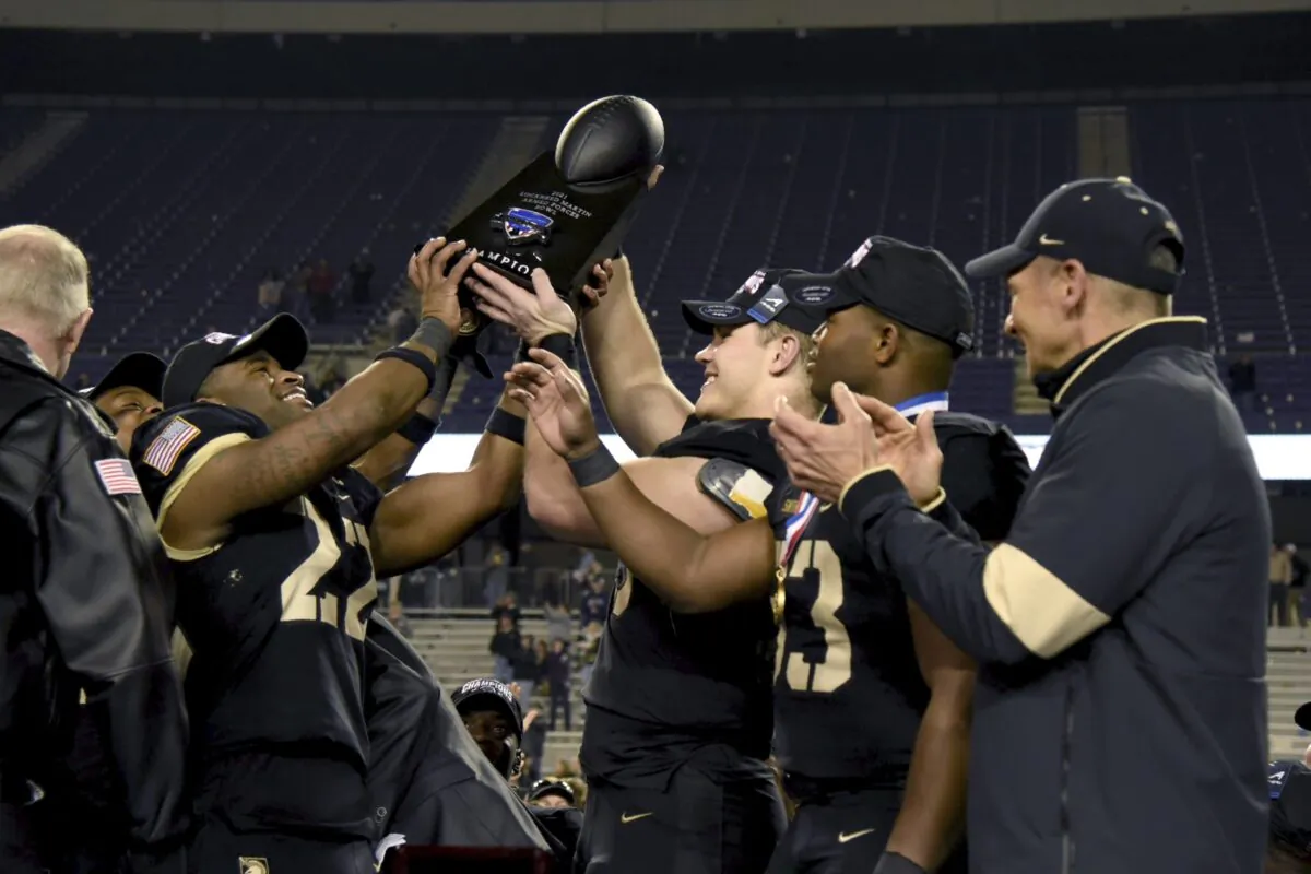 Army head coach Jeff Monken, right, looks on as his team celebrate with the trophy after their win in the Armed Forces Bowl NCAA college football game against Missouri in FORT WORTH, Texas, on Dec. 22, 2021. (Emil Lippe/AP Photo)