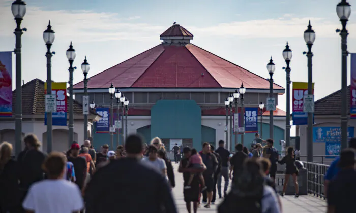 People walk past the former Ruby's Diner site, which stopped operation in February 2021, at the end of the Huntington Beach Pier in Huntington Beach, Calif., on Sept. 22, 2021. (John Fredricks/The Epoch Times)