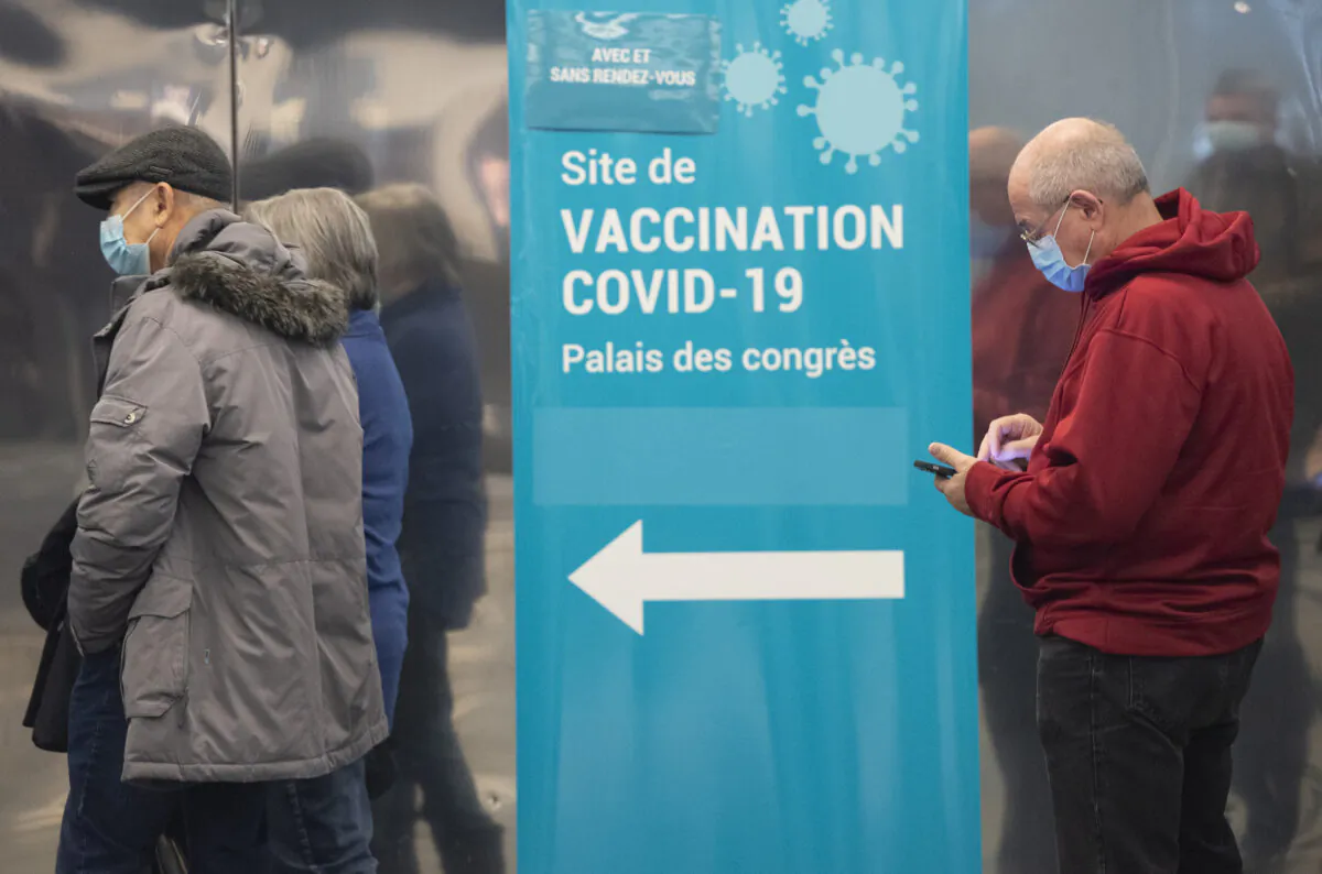 People wait to receive a COVID-19 vaccination in Montreal on Dec. 17, 2021. (Graham Hughes/The Canadian Press)