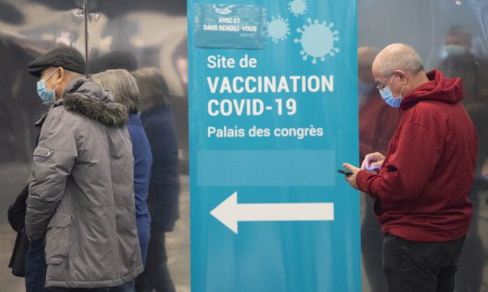 People wait to receive a COVID-19 vaccination in Montreal, on Dec. 17, 2021. (Graham Hughes/The Canadian Press)
