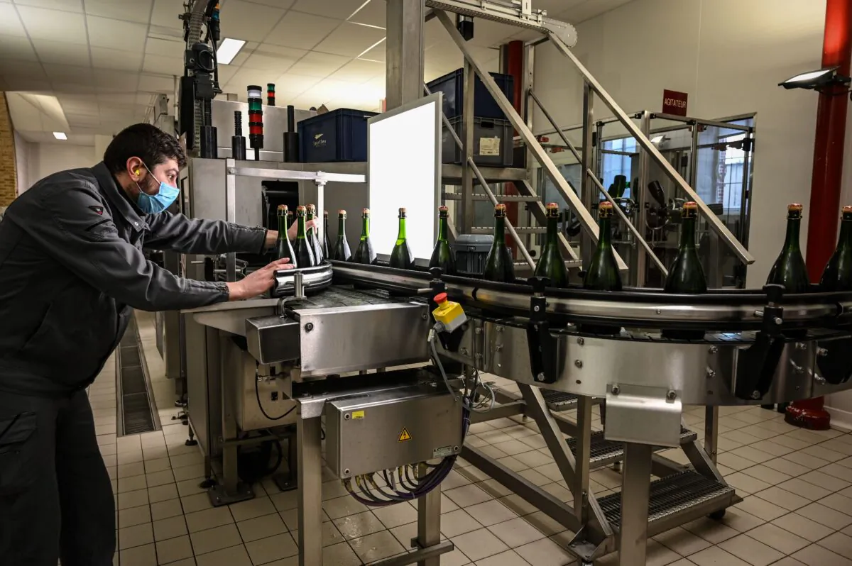 An employee conducts quality control at the French champagne house Bollinger, in Ay, near Epernay, France, on Dec. 2, 2020. (Bertrand Guay/AFP via Getty Images)