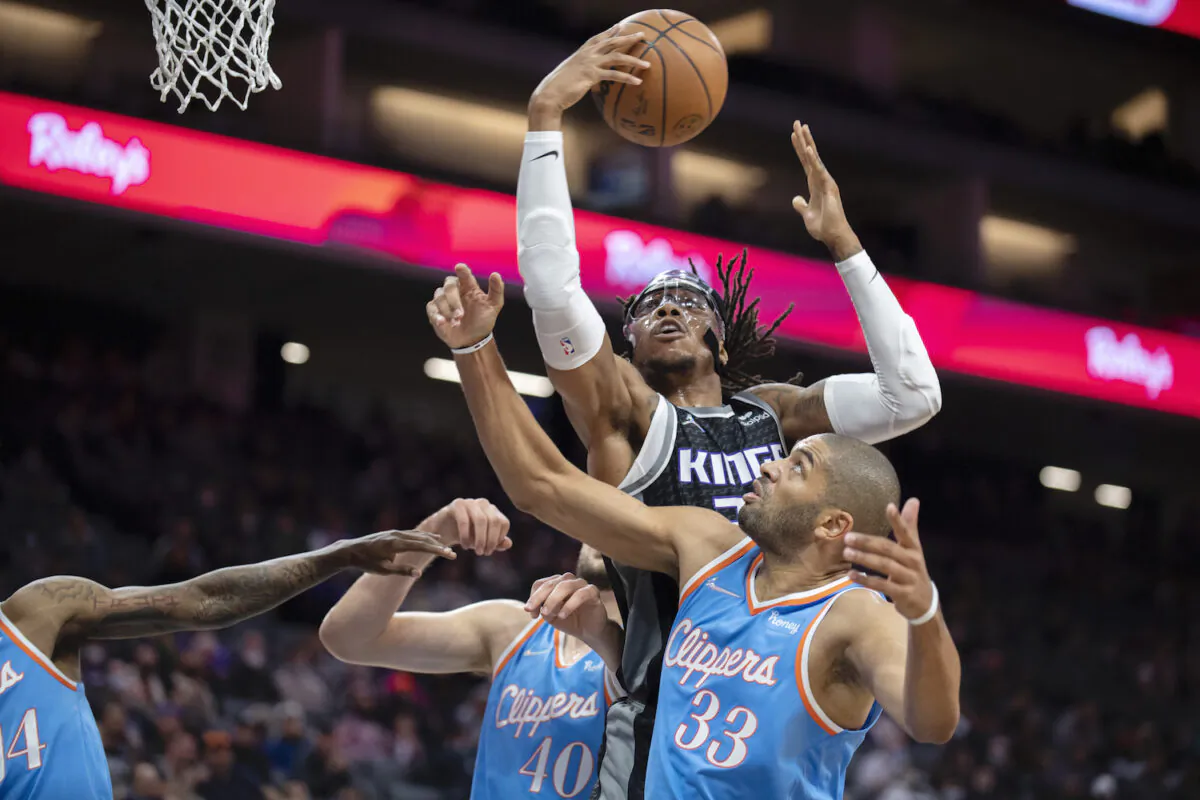 Sacramento Kings center Richaun Holmes (22) pulls down a rebound between LA Clippers forward Nicolas Batum (33) and Ivica Zubac (40) during the first quarter of an NBA basketball game in Sacramento, Calif., on Dec. 22, 2021. (AP Photo/José luis Villegas)