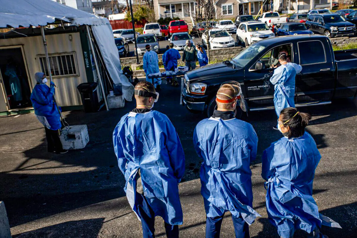 Healthcare workers administer free COVID-19 tests to people in their cars in the parking lot of the Columbus West Family Health and Wellness Center, in Columbus, Ohio, on Nov. 19, 2020. (Stephen Zenner/AFP via Getty Images)