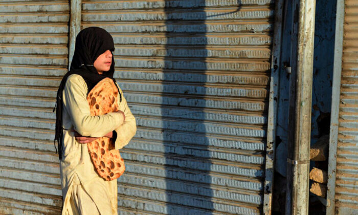 A boy carries freshly baked bread along a street in Kandahar on October 27, 2021. 24 million people in Afghanistan are in need of humanitarian assistance after August 15. (Javed Tanveer/ AFP) 