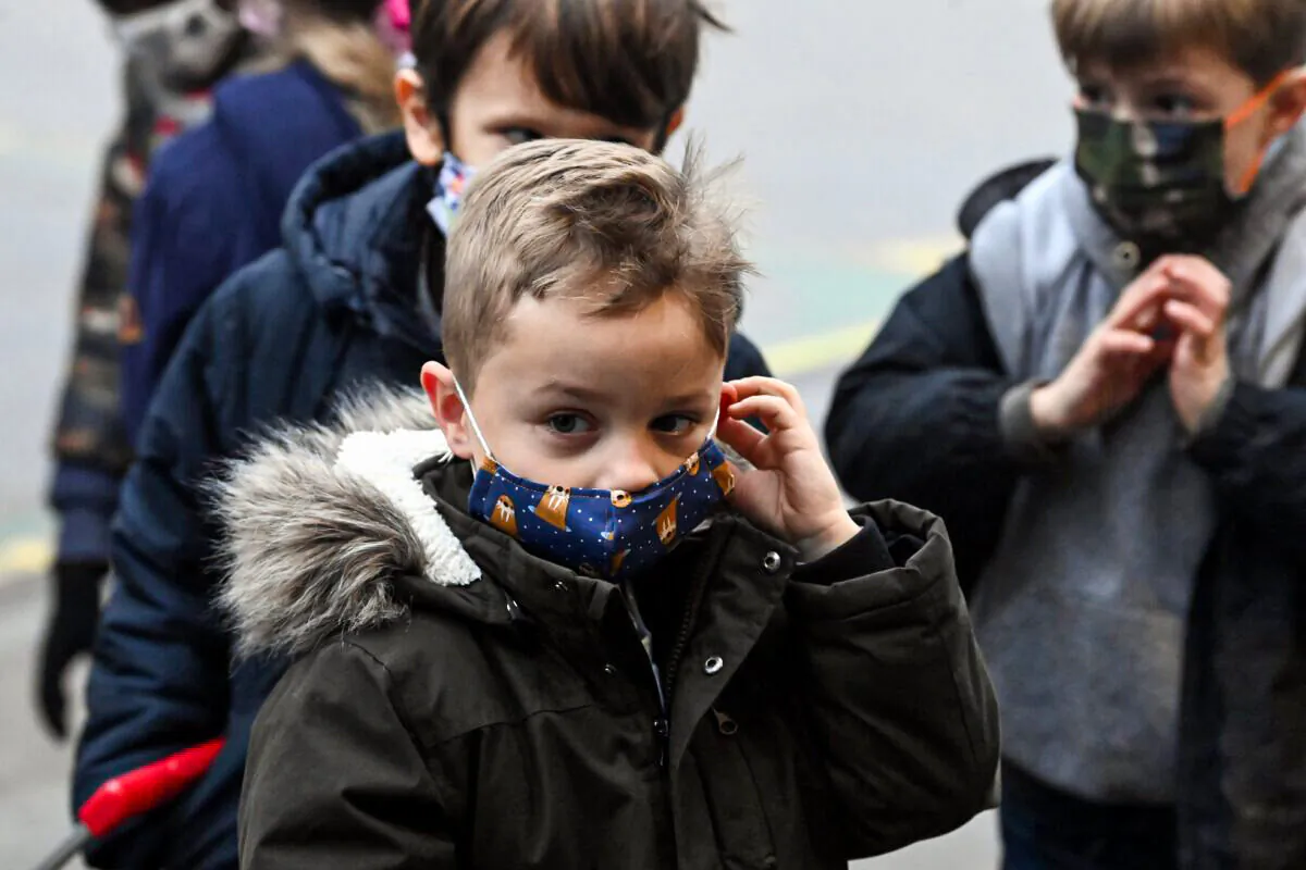 Children wear masks on the playground of a primary school in Helecine, Belgium, on Dec. 6, 2021. (Eric Lalmand/Belga Mag/AFP via Getty Images)