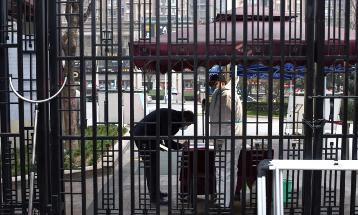 A security guard checks the information of a man at the entrance of a residential area that is under restriction following a recent COVID-19 outbreak in Xian, in China's northern Shaanxi Province on December 23, 2021. (STR/AFP via Getty Images)