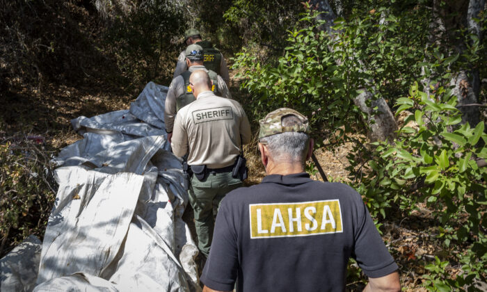 Los Angeles Homeless Services Authority workers join the Los angeles Sheriff's Department in assisting homeless individuals in Malibu, Calif., on Sept. 24, 2021. (John Fredricks/The Epoch Times)