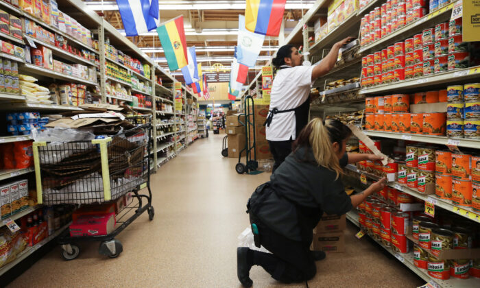 Workers re-stock items at a supermarket in Los Angeles on March 19, 2020. (Mario Tama/Getty Images)