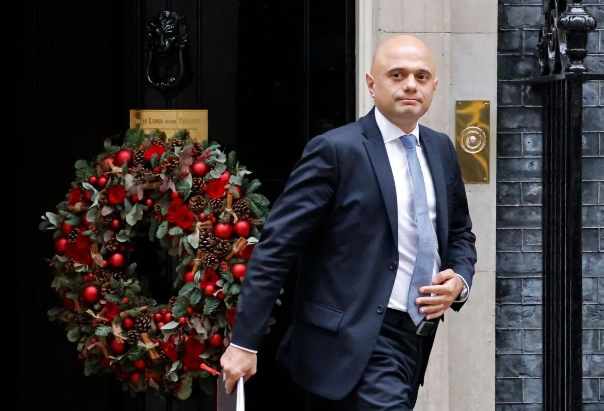 Britain's Health Secretary Sajid Javid passes a Christmas wreath as he leaves from 10 Downing Street in London on Dec. 15, 2021. (Tolga Akmen /AFP via Getty Images)