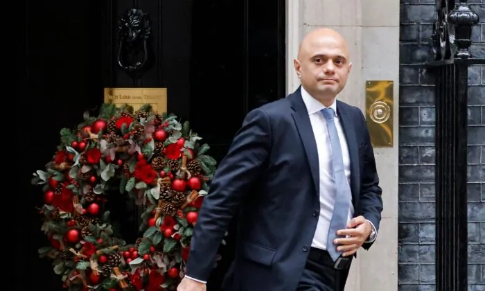 Britain's Health Secretary Sajid Javid passes a Christmas wreath as he leaves from 10 Downing Street in London on Dec. 15, 2021. (Tolga Akmen /AFP via Getty Images)