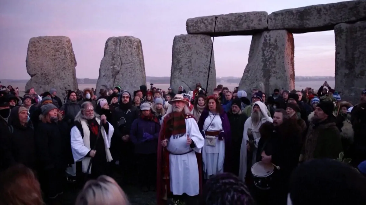 People gather at the Stonehenge stone circle singing to mark the winter solstice on Dec. 22, 2021, in a still from video. (Reuters/Screenshot via The Epoch Times)