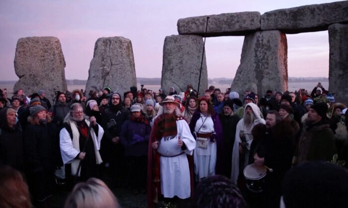 People gather at the Stonehenge stone circle singing to mark the winter solstice on Dec. 22, 2021, in a still from video. (Reuters/Screenshot via The Epoch Times)