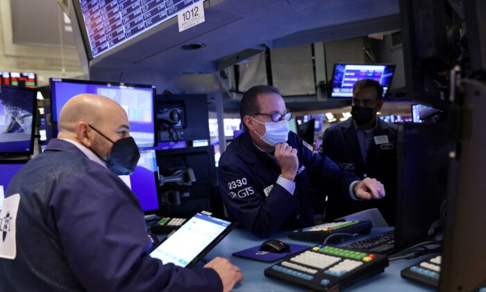 Traders wearing face masks work on the trading floor at the New York Stock Exchange (NYSE) as the Omicron coronavirus variant continues to spread in Manhattan, New York City, on Dec. 20, 2021. (Andrew Kelly/Reuters)