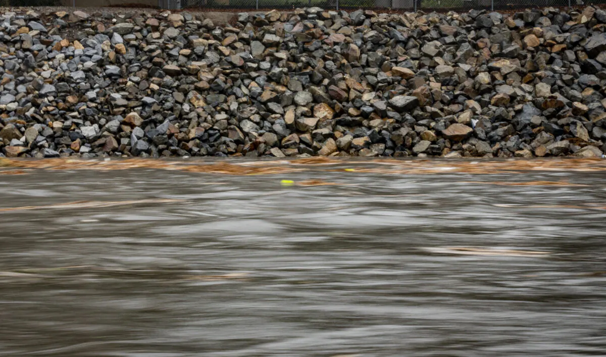 Water rushes down the San Diego Creek channel during a rain storm, in Irvine, Calif., on Dec. 12, 2021. (John Fredricks/The Epoch Times)