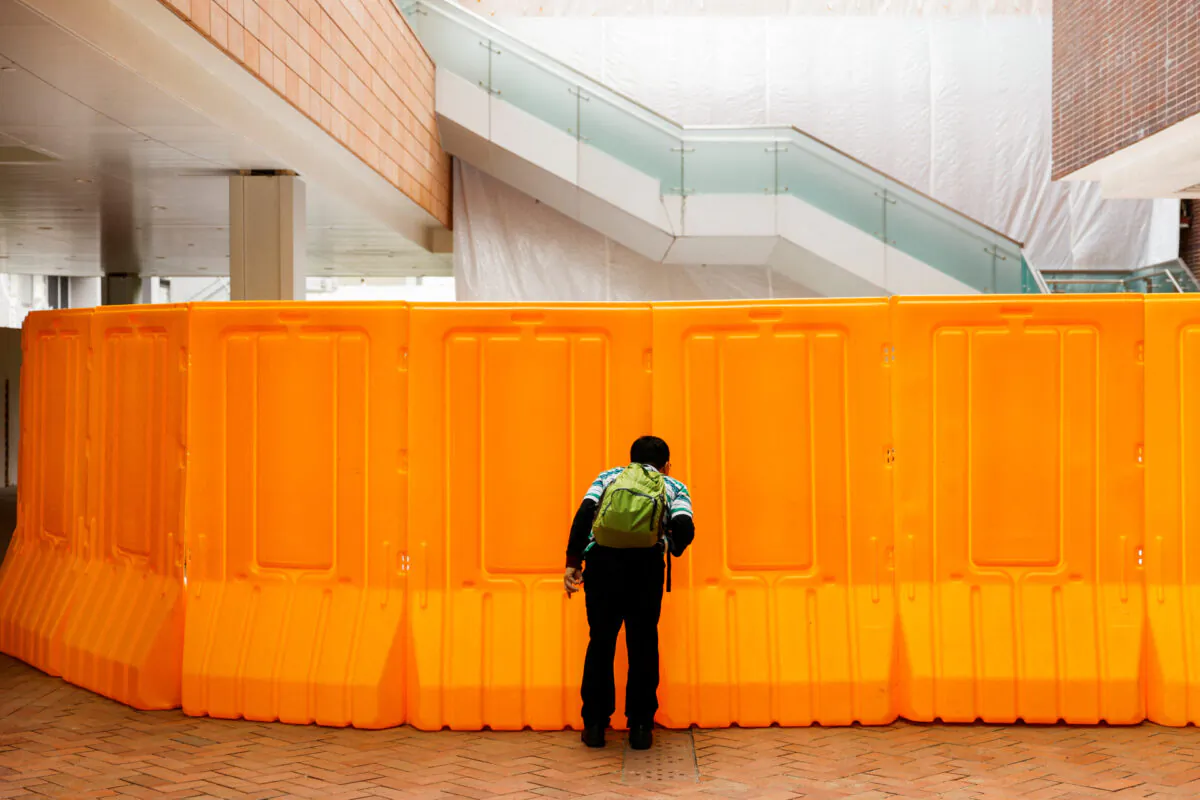 A man tries to peep into the site where the "Pillar of Shame" statue by Danish sculptor Jens Galschiot which pays tribute to the victims of the Tiananmen Square crackdown in Beijing on June 4, 1989, used to stand, after being removed at the University of Hong Kong (HKU) in Hong Kong, on Dec. 23, 2021. (Tyrone Siu/Reuters)