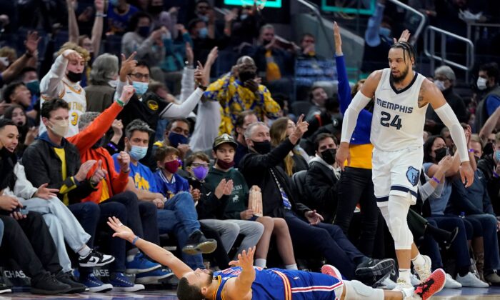 Golden State Warriors guard Stephen Curry, bottom, celebrates after shooting a 3-point basket next to Memphis Grizzlies forward Dillon Brooks (24) during the second half of an NBA basketball game in San Francisco, on Dec. 23, 2021. (Jeff Chiu/AP Photo)