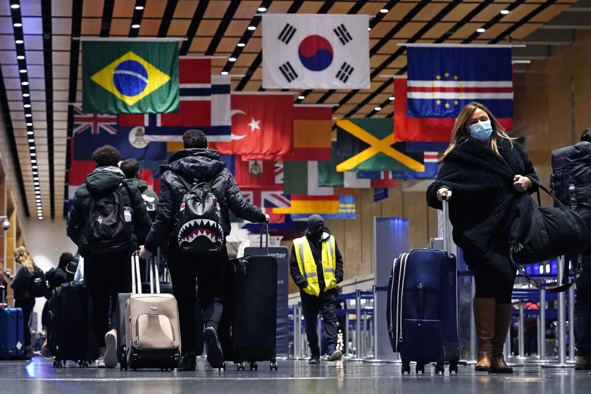Travelers trek through Terminal E at Logan Airport in Boston, on Dec. 21, 2021. (Charles Krupa/AP Photo)